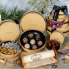 Decorative chocolate assortment in a Swarovski branded box with a mask and festive items on a neutral background.
