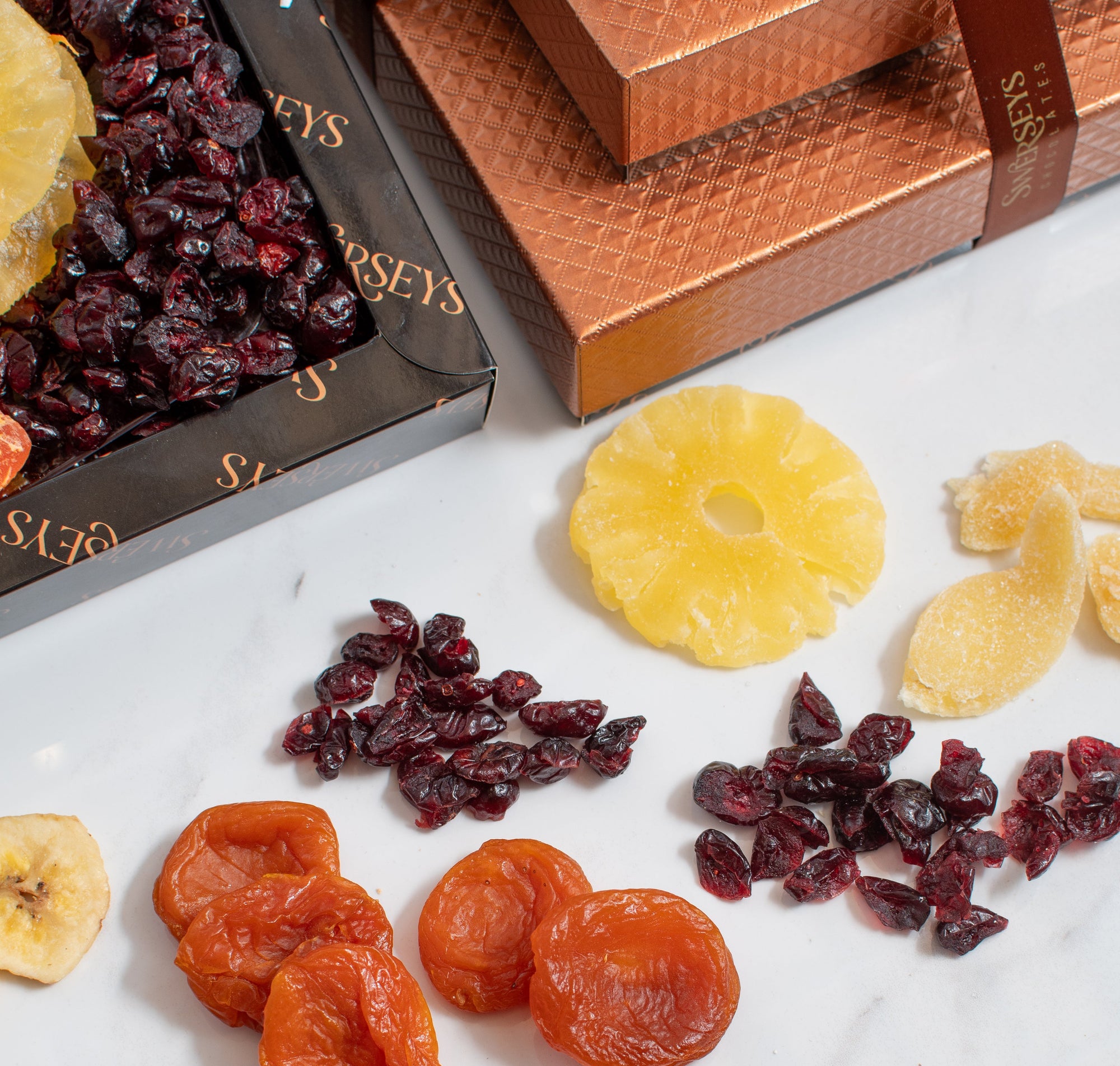 Dried fruits on a marble surface with a branded box in the background