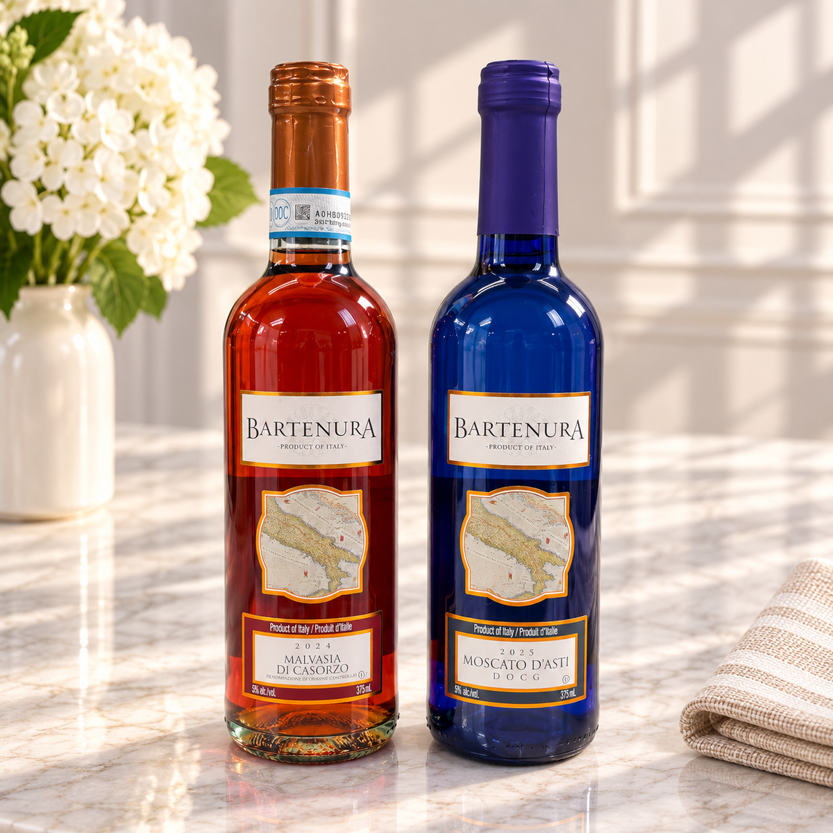 Kosherline Bartenura Malvasia di Casorzo and Moscato d'Asti wine bottles on a marble table with white flowers