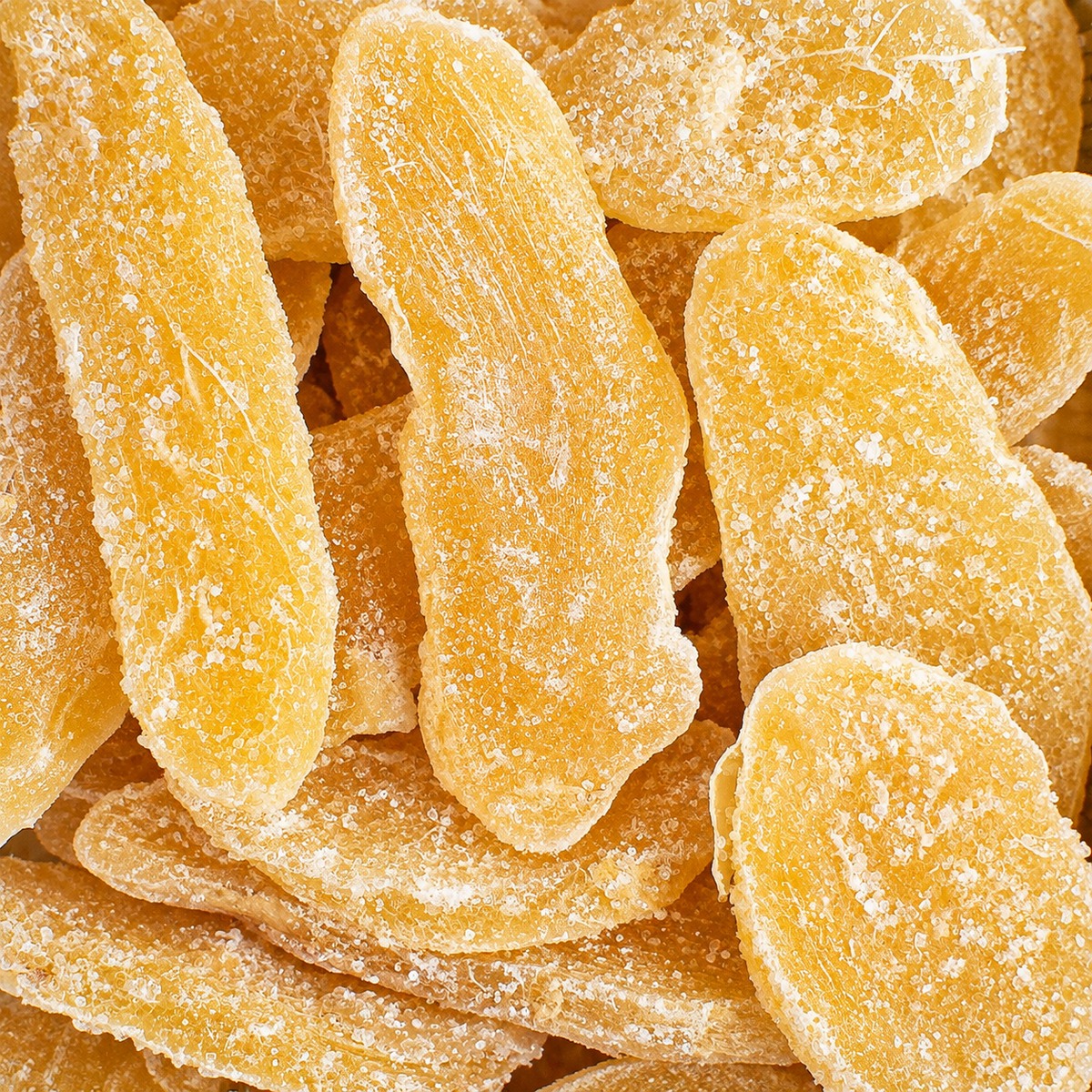 Kosherline candied ginger slices coated in sugar, featuring a vibrant golden yellow color and chewy texture.
