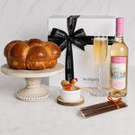 Kosherline Shabbat and Yom Tov gift box featuring a fresh challah, Bartenura Moscato, honey sticks, and a dipper.
