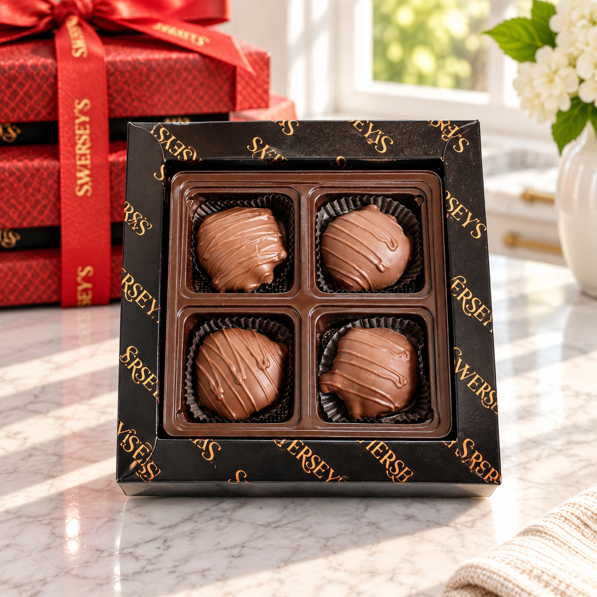 Kosherline 3 tier chocolate gift tower featuring four milk chocolate covered treats in a black branded box