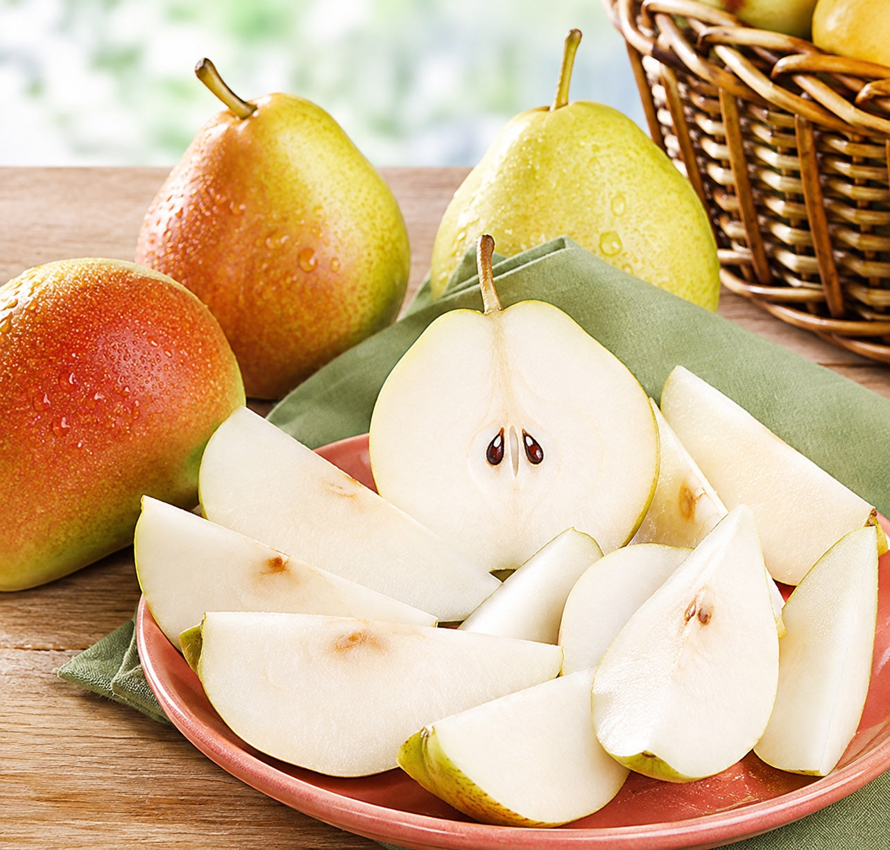 Kosherline Rosh Hashana gift basket featuring fresh sliced pears on a plate with whole pears in the background