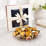 Kosherline assorted gourmet rugelach pastries with chocolate and cinnamon on a glass plate with a gift box.