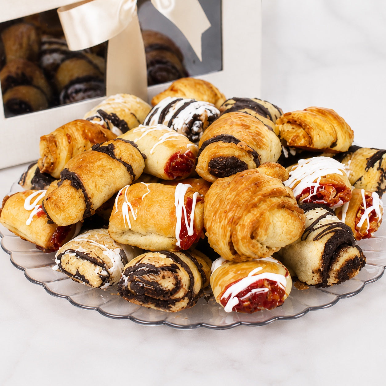 Kosherline assorted gourmet rugelach pastries with chocolate and fruit fillings on a clear platter for Rosh Hashanah