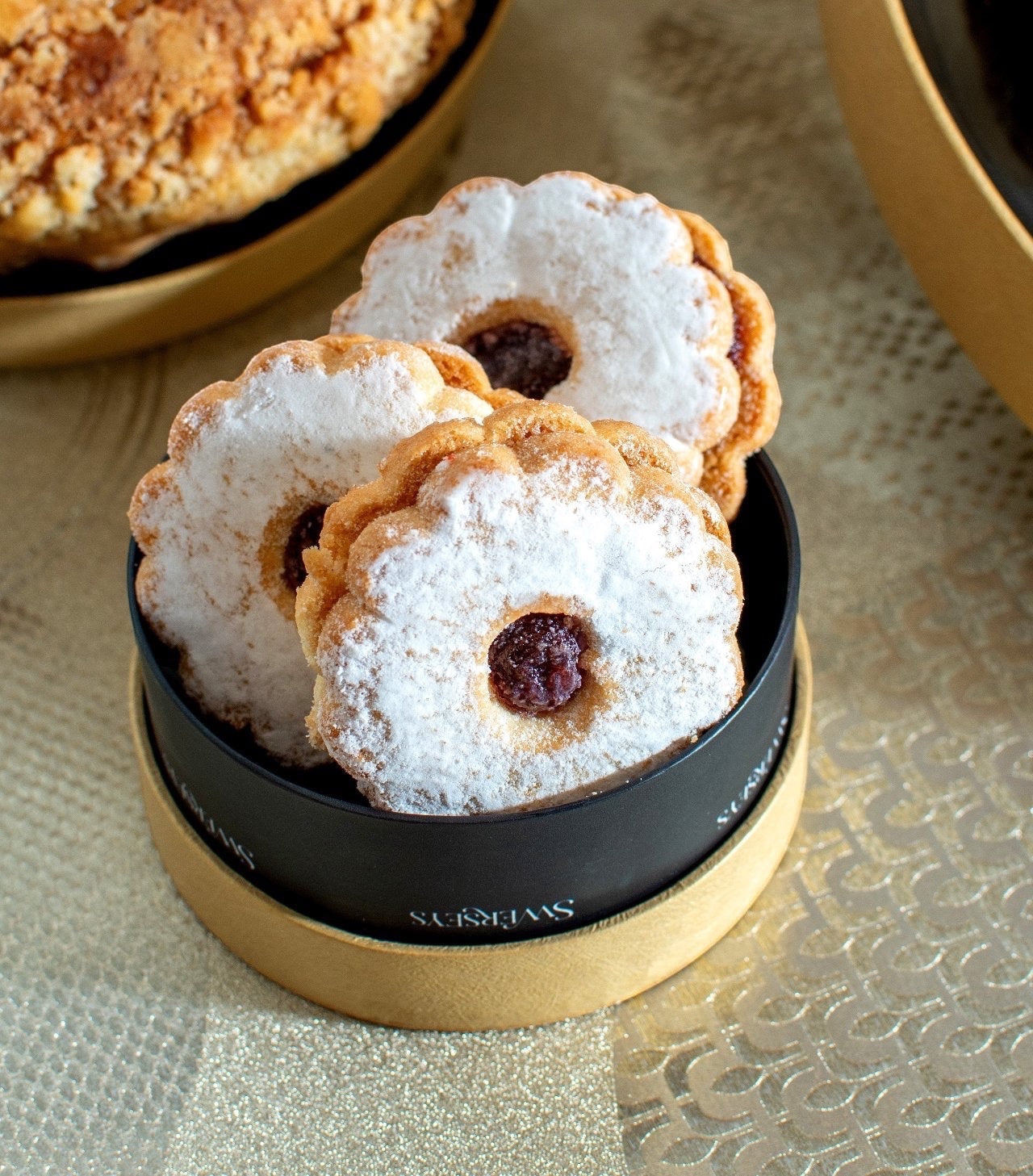 Kosherline gourmet Linzer cookies with fruit preserves and powdered sugar in a round gold gift box tier