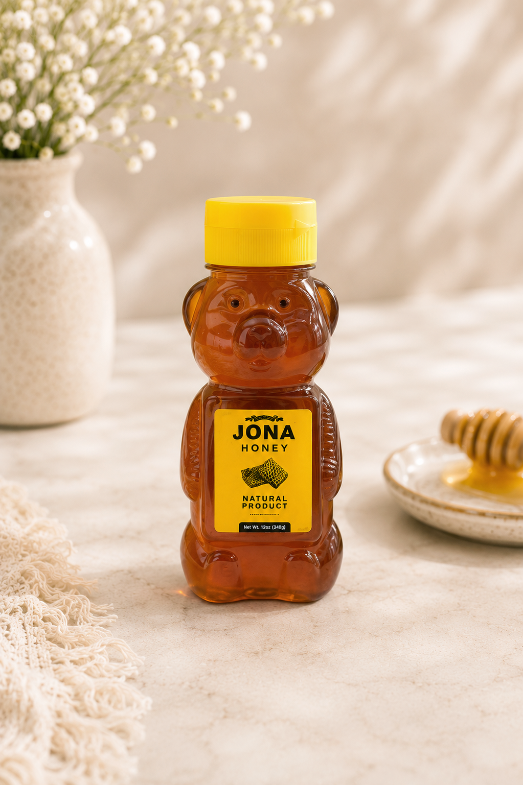 Kosherline Rosh Hashanah honey in a classic bear-shaped plastic bottle with a yellow cap on a textured table.