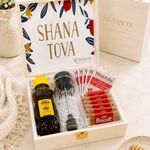 Kosherline Rosh Hashanah gift set featuring honey, a honey dipper, herbal tea, and Biscoff cookies in a wooden box.