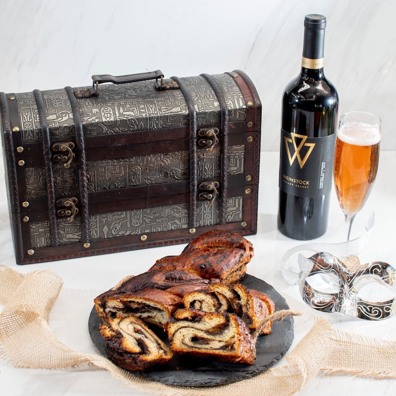 Kosherline Rosh Hashanah gift set with chocolate babka, premium wine, and a decorative treasure chest on a table.