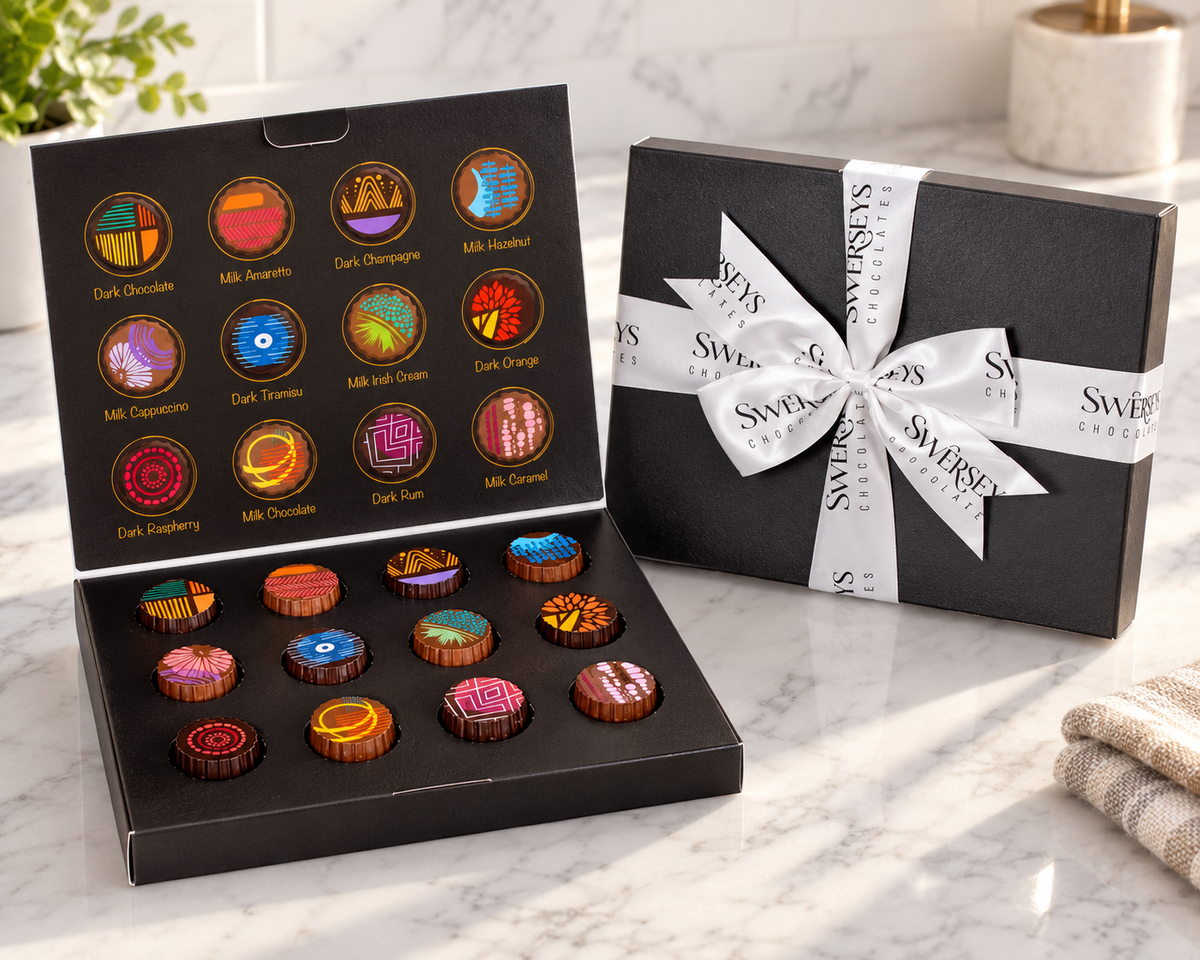 Kosherline Swerseys artistic truffles in a black gift box with a white branded ribbon on a marble countertop