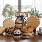 Kosherline Swerseys gourmet 3-tier gold round gift box featuring bundt cake, rugelach, and Linzer cookies on a table.