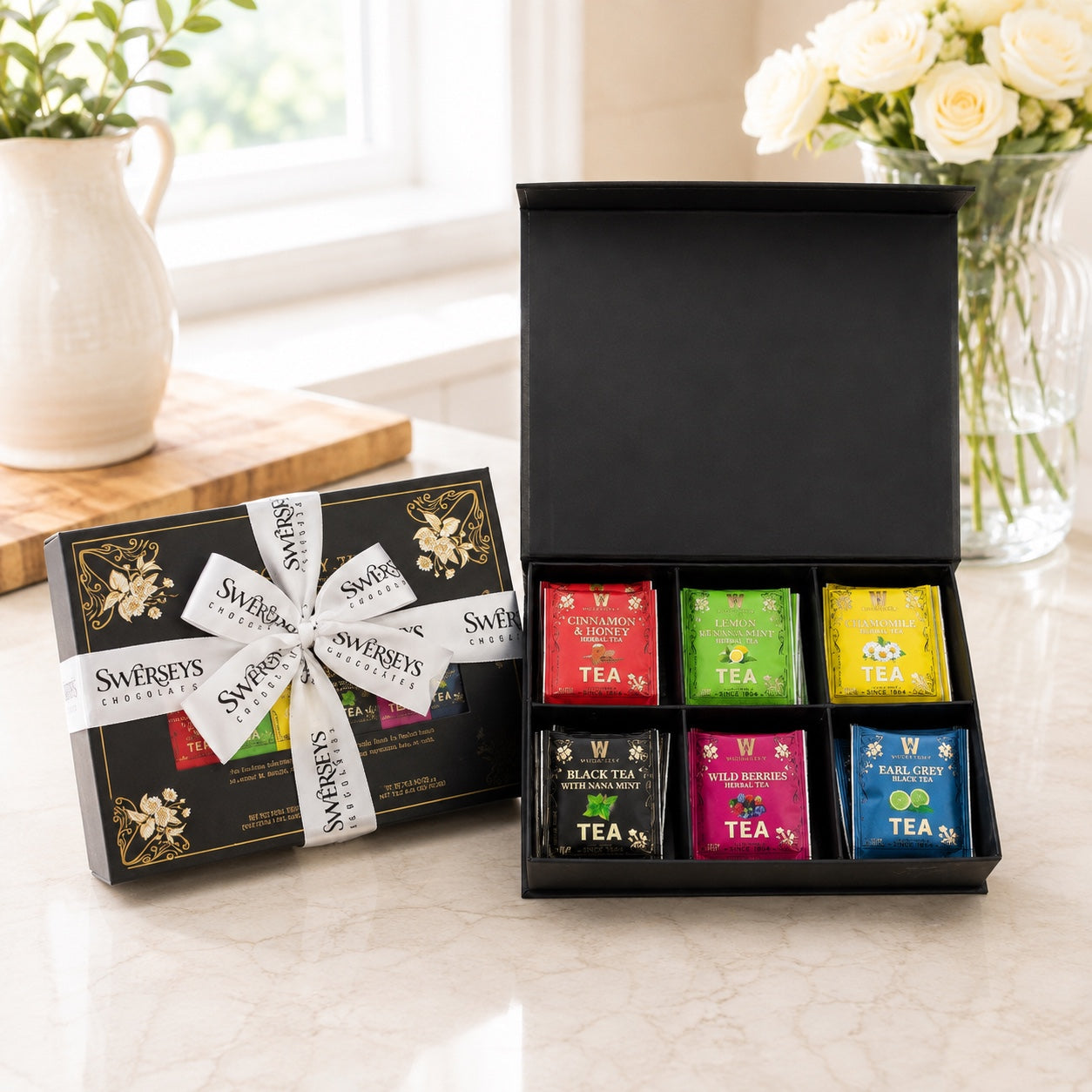 Kosherline gift box featuring six assorted tea bags and cinnamon twist pastries in elegant black packaging